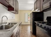 Thumbnail 7 of 18 - a kitchen with a sink a stove and a refrigerator