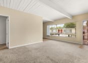 Thumbnail 9 of 18 - a bedroom with a large window and beige carpet