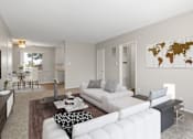 Thumbnail 2 of 23 - A living room with a white couch and a world map on the wall.