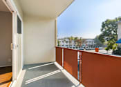 Thumbnail 7 of 47 - A balcony with a white door and orange railing.