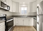 Thumbnail 4 of 47 - A kitchen with white cabinets and stainless steel appliances.