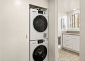 Thumbnail 9 of 47 - A white front loading washing machine in a laundry room.