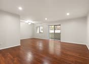 Thumbnail 2 of 44 - A room with wooden flooring and a sliding glass door.