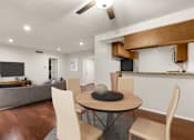 Thumbnail 5 of 44 - A modern living room with a grey sofa, a wooden dining table and chairs, and a kitchen area with a wooden countertop.