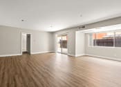 Thumbnail 17 of 38 - an empty living room with a large window and hardwood floors