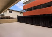 Thumbnail 16 of 38 - a view of the back of a building with a black fence and an orange building in the