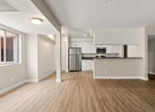 Thumbnail 13 of 38 - an empty living room with a kitchen in the background
