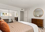 Thumbnail 15 of 69 - A bedroom with a bed, dresser, and mirror.