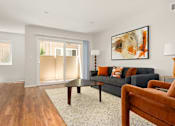 Thumbnail 12 of 69 - A living room with a couch, a chair, and a painting on the wall.