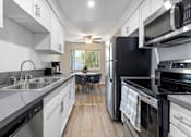Thumbnail 1 of 69 - a kitchen with white cabinets and black appliances at Lombardi Apartments, Woodland Hills, CA, 91367