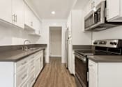 Thumbnail 22 of 69 - a kitchen with white cabinets and stainless steel appliances at Lombardi Apartments, Woodland Hills, California