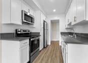 Thumbnail 52 of 69 - A modern kitchen with white cabinets and stainless steel appliances.