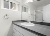 Thumbnail 59 of 69 - A bathroom with a sink and mirror.
