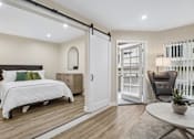 Thumbnail 6 of 55 - A bedroom with a bed, chair, and sliding door.
