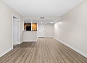 Thumbnail 39 of 54 - an empty living room with a kitchen in the background at Woodland Trio Apartments, North Hollywood, CA, 91601