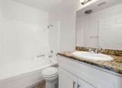 Thumbnail 5 of 40 - A white bathroom with a toilet, sink, and tub.