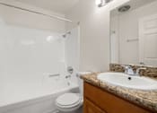 Thumbnail 33 of 40 - A white toilet sits next to a sink in a bathroom.
