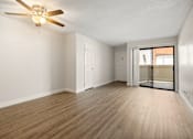 Thumbnail 2 of 40 - A room with a ceiling fan and wooden flooring.