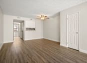 Thumbnail 29 of 40 - A room with a ceiling fan and wooden flooring.