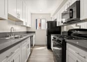 Thumbnail 9 of 40 - a kitchen with black appliances and white cabinets