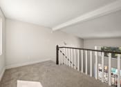 Thumbnail 12 of 40 - the upstairs loft of a house with carpeted stairs and a window