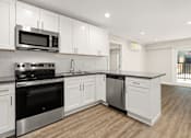 Thumbnail 26 of 54 - a kitchen with white cabinets and a stove and a microwave at Woodland Trio Apartments, North Hollywood, CA
