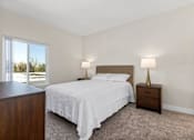Thumbnail 18 of 54 - a bedroom with a bed and a window at Woodland Trio Apartments, California