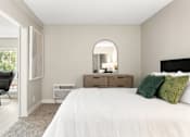 Thumbnail 9 of 54 - A bedroom with a large bed, a chair, and a mirror.