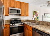 Thumbnail 2 of 54 - A kitchen with a stainless steel refrigerator, a stove, and a microwave above the stove.