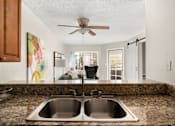 Thumbnail 3 of 54 - A kitchen with a double sink and a ceiling fan.