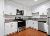 Thumbnail 32 of 60 - a kitchen with white cabinets and stainless steel appliances at The Meadows at Westlake Village Apartments,California, 91361
