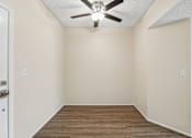 Thumbnail 13 of 55 - A room with a ceiling fan and wooden flooring.