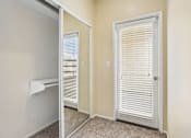 Thumbnail 18 of 55 - A room with a white door and a window with blinds.