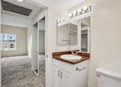 Thumbnail 21 of 55 - A bathroom with a brown countertop and white cabinets