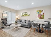 Thumbnail 2 of 55 - A living room with a grey couch, a white coffee table, and a painting on the wall.