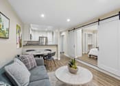 Thumbnail 4 of 55 - A modern living room with a grey sofa and a white coffee table.