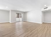 Thumbnail 8 of 38 - an empty living room with white walls and wood flooring