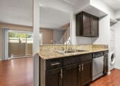 Thumbnail 43 of 60 - Kitchen with Granite Countertops, New Espresso Cabinetry, Wood Flooring and Stainless Steel Appliances at The Meadows at Westlake Village Apartments, Westlake Village, CA