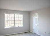 Thumbnail 38 of 94 - A room with a white door and a window with blinds.