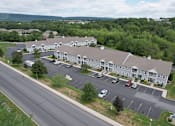 Thumbnail 24 of 24 - A large white building with a parking lot in front of it.