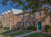 Thumbnail 16 of 17 - A row of red brick houses with green doors.