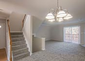 Thumbnail 89 of 94 - A living room with a grey carpet and a chandelier.