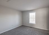 Thumbnail 92 of 94 - A room with a window and carpeted floor.