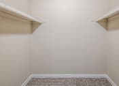 Thumbnail 28 of 37 - A room with a carpeted floor and two shelves.