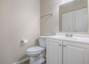 Thumbnail 18 of 37 - A white toilet sits next to a sink in a bathroom.