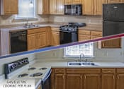 Thumbnail 1 of 18 - A kitchen with a black refrigerator and a white stove top oven.