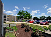 Thumbnail 11 of 12 - A parking lot with cars and a building in the background.