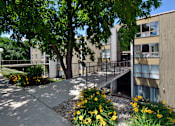Thumbnail 10 of 12 - A concrete building with a tree in front of it.