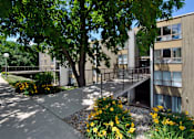 Thumbnail 8 of 12 - A concrete building with a tree in front of it.