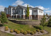 Thumbnail 7 of 25 - A large, modern building with a landscaped front yard at Abbey Ridge Apartment Homes, Oxford, MI, Michigan